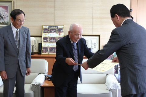 松井市長から内閣府の賞状の伝達を受ける山崎さん（中央）と尾白さん（左）
