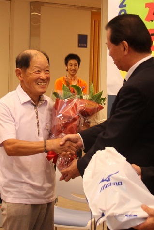 松井市長から記念品を受け取る笑顔の小林さんの写真