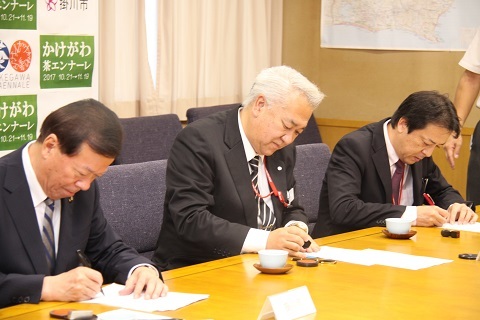 協定書にサインをする松井市長、小林局長、鈴木局長の写真