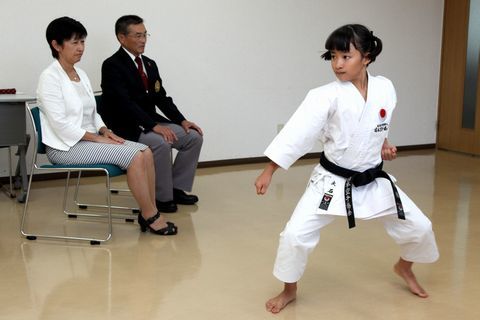 柔道着を着て演武を披露する大石さんとそれを眺める山田教育長と女性