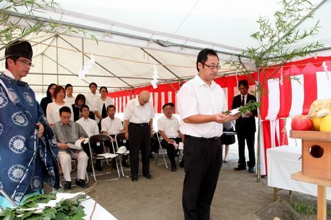 玉串を捧げるあそび学園の馬塚孝雅社長とそれを眺める参列者