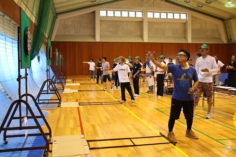 体育館に設置されたダーツゲームに挑戦する参加者たち