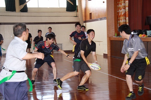 体育館でタグラグビーを指導してもらいゲームをする小学校教員