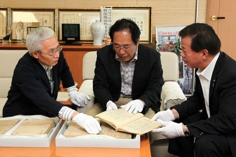 江戸時代の歴史資料である「掛川誌稿」を松井市長に説明する旧山崎家当主の良太郎さんと文三さん