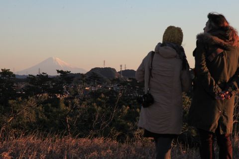 白んだ空と富士山を眺める女性と男性