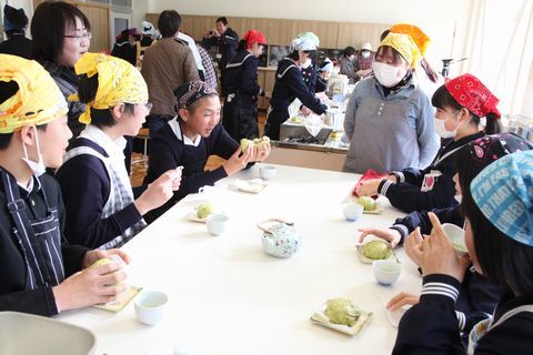お茶を飲みながら、完成した肉まんを試食する生徒たち