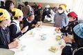 お茶を飲みながら、完成した肉まんを試食する生徒たち