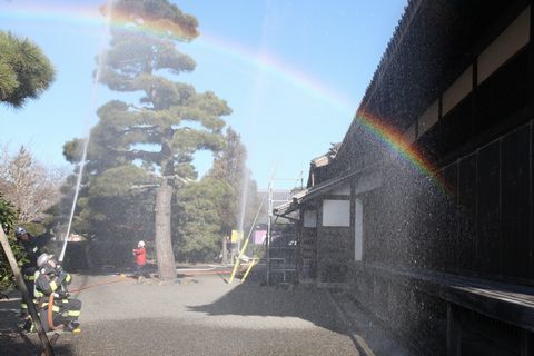 消防隊員が消防服を着用し、掛川城御殿に放水している