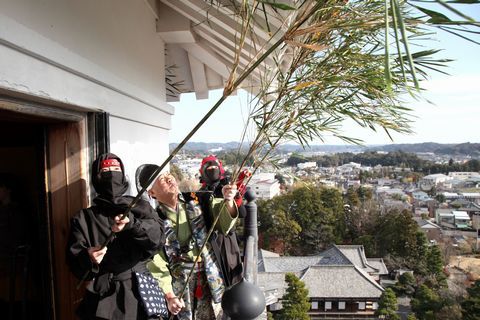 6メートルから7メートルほどの笹竹を使い、天守閣の外壁や軒下などについた「すす」やほこり、クモの巣などをとり払う写真