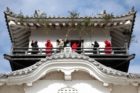 武将や忍者にふんした掛川城の観光ボランティア「掛川城戦国おもてなし隊」メンバーが掛川城天守閣のすす払いを行う写真