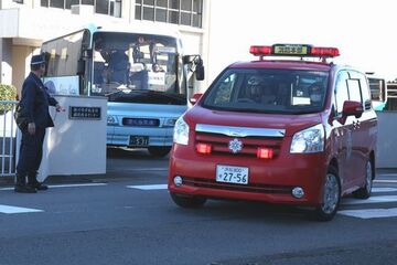 消防署職員の車に先導され出発するバス