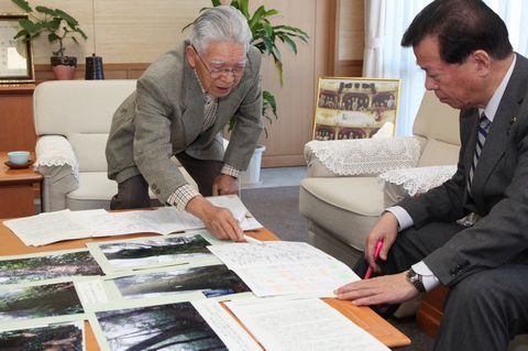 松井市長に粟ヶ岳山頂付近で行った樹木調査結果を報告する佐藤会長（男性）