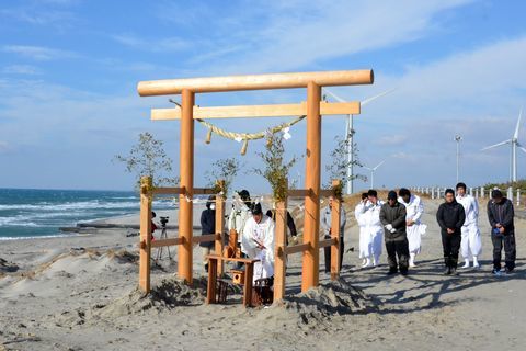 設置した鳥居でおはらいをする神主と祈祷をうける掛川観光協会大東支部のひとたち