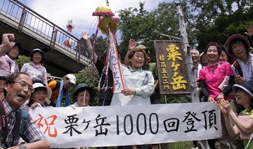 くす玉を割って見せる加藤泠子さんと、加藤さんを取り囲み祝う人たち