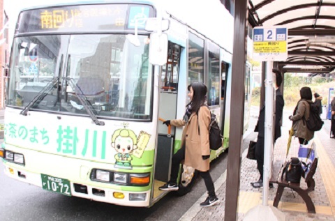 掛川市の自主運行ラッピングバスに乗り込む乗客。掛川市のご当地キャラクターの茶きんじろうくんの絵がかかれている。