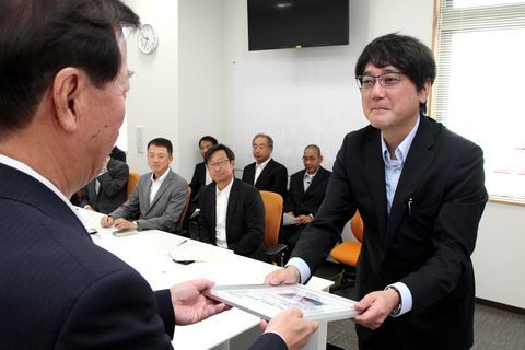 松井市長から認定証を受け取る岩崎代表理事とそれを見ている関係者たち