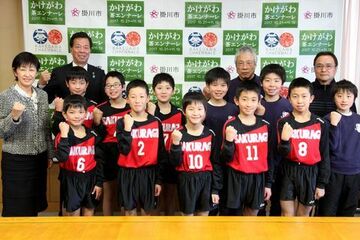 ユニフォームを着てガッツポーズをする少年団の選手らの写真