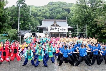 緑の木々に囲まれた境内のメインステージで総踊りを楽しむ大勢の参加者