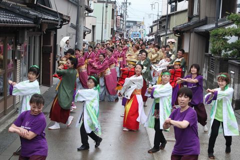 両側に民家が立ち並ぶ横須賀街道でカラフルな衣装着てよさこい演舞を披露する参加者たち