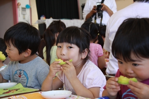 カットされたメロンを手に持って食べる園児たち