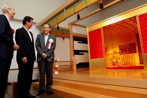 黄金の茶室の前に立って話す松井市長と2人の男性