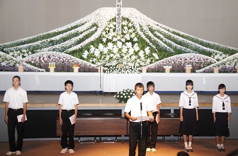 献花台を背に平和への誓いを新たにする生徒たち