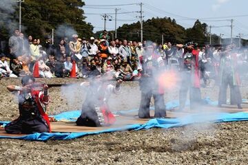 ギャラリーの前で火縄銃の射撃を実演する駿府古式炮術研究会の人たちの写真