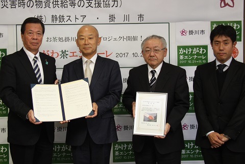 協定書を持つ竹田社長と松井市長を含む4人の男性