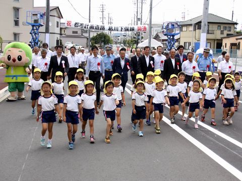 先頭に幼稚園児が横に並び、次に市長・来賓の方々、最後に自治体関係者が並び、通り初めをしている様子。