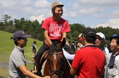 乗馬体験を楽しむ赤い服を着た参加者