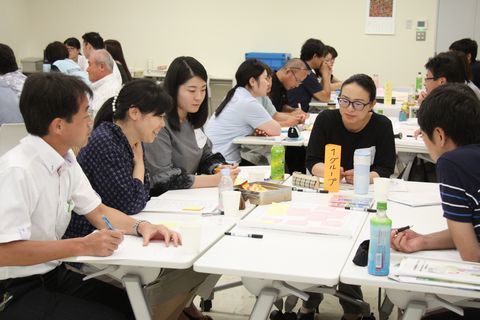掛川市の地域包括システムや取り組み事例を分析する参加者。グループ毎に5名から6名ほどで机を囲んでいる。
