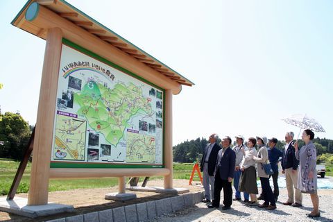 案内看板を見上げる倉真地区の役員ら