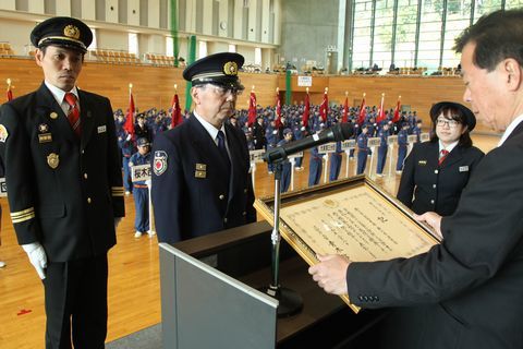 消防庁長官表彰「竿頭綬」の伝達を受ける遠藤分団長（左）と白畑消防長