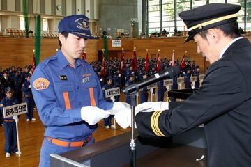 入団者代表として遠藤団長（右）から任命書を受け取る大東第5分団の永井諒さん