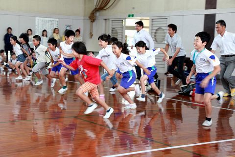 体育館内で行われた防犯教室で、不審者役の保護者から走って逃げる練習をする児童の様子