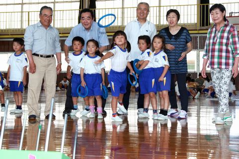 体育館で地域の先輩たちと輪投げを楽しむ児童たちの様子