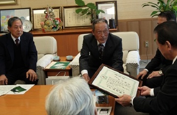 表彰状を披露し談話している様子