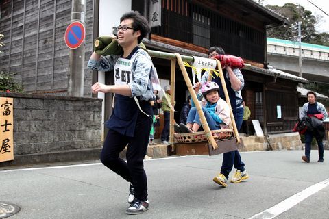 子どもを乗せた駕籠を2人1組で担いで旧東海道を駆け抜ける選手の様子