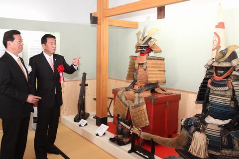 杉良太郎さんが甲冑に指を刺しながら、松井市長に説明する様子
