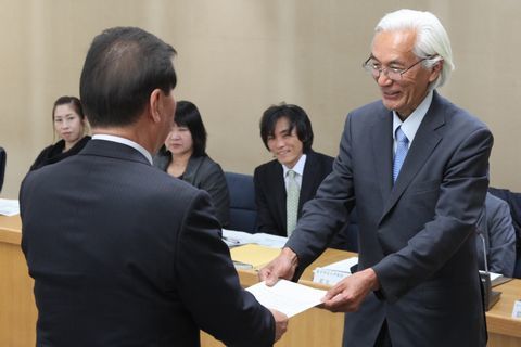 委員の前で、市長から諮問を受ける鷲山会長の様子