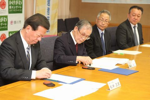 松井市長と横田理事長が協定書に押印する様子