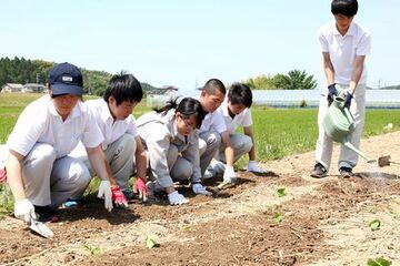 手にスコップやジョウロを持ち、葛の苗木定植に汗を流す小笠高校生たち