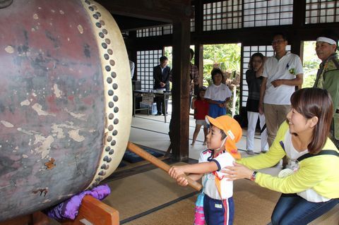 来場者に見守られながら自分の体よりも大きな太鼓を鳴らす参加者たち