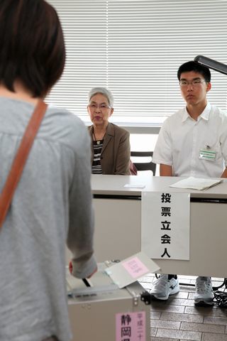 真剣な表情で投票立会人を務める男子生徒（右）