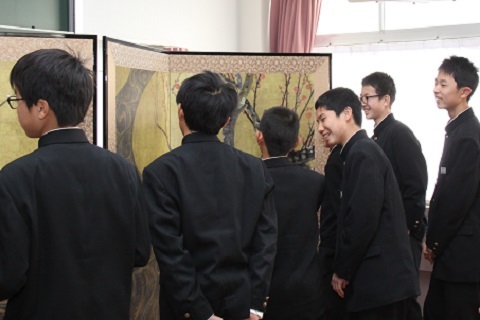 光琳の屏風の前で笑顔で作品を鑑賞する生徒たちの写真
