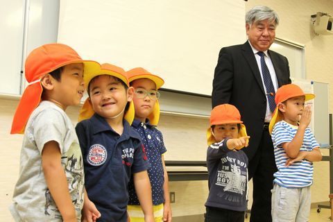 入園の証のオレンジ色の帽子をかぶり嬉しそうな表情の園児たちと、時ノ寿学校の宮林学長（右）