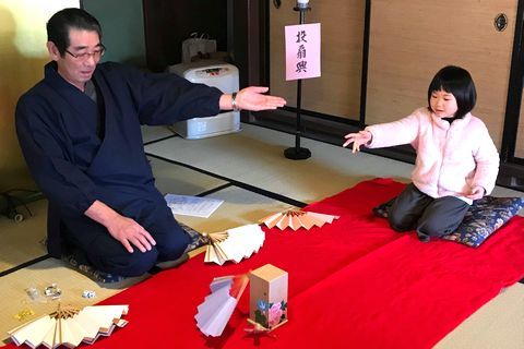 日本伝統遊戯である投扇興を楽しんでいる来園者の様子