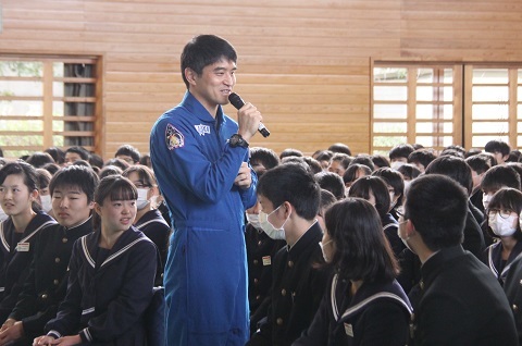 生徒と保護者など700人の前で宇宙ステーションでの生活について語る大西さんの写真
