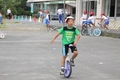 一輪車に乗って100メートル走行に挑戦する児童のようす