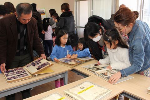 園の活動を記録したアルバムに見入る来園者の様子